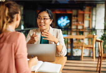 two people meeting at a table having a discussion