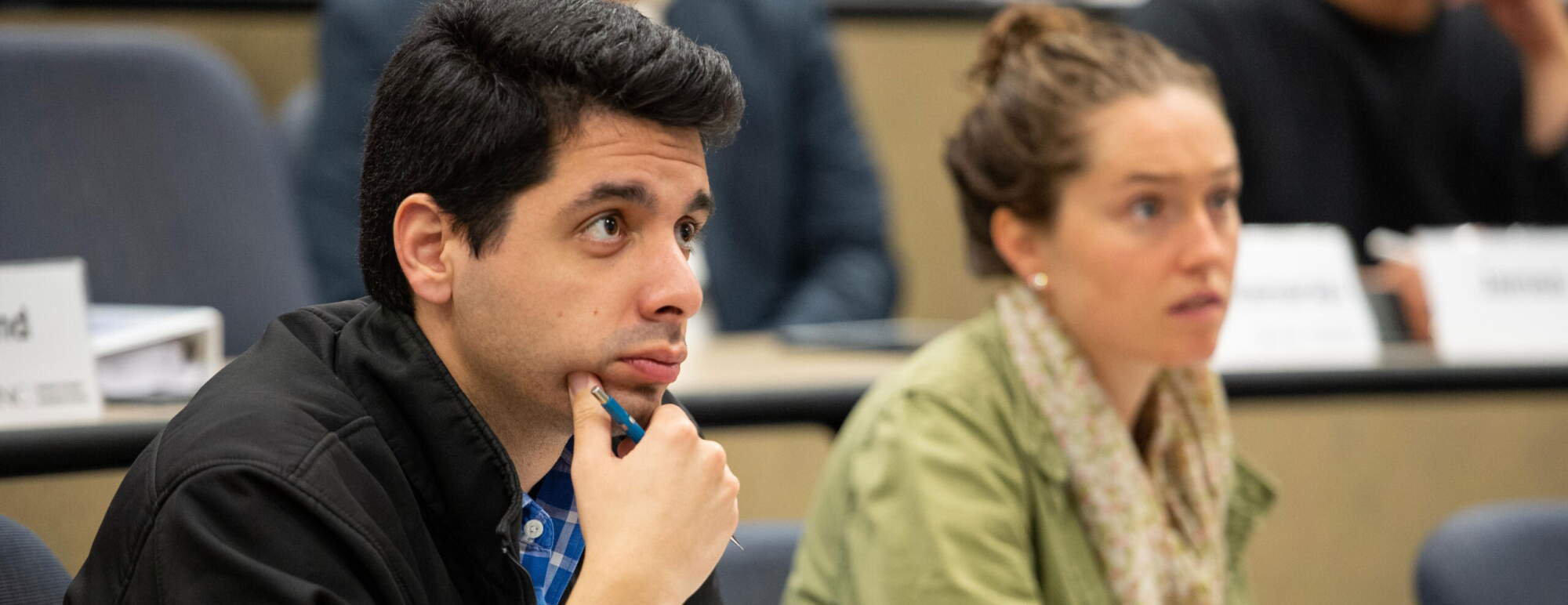 two students listen in a class lecture