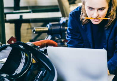 Focused female student using a laptop to look up a solution for her experiment to complete her final project.