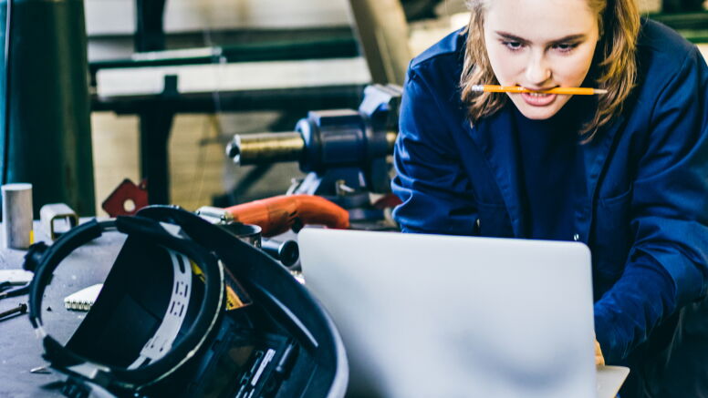 Focused female student using a laptop to look up a solution for her experiment to complete her final project.