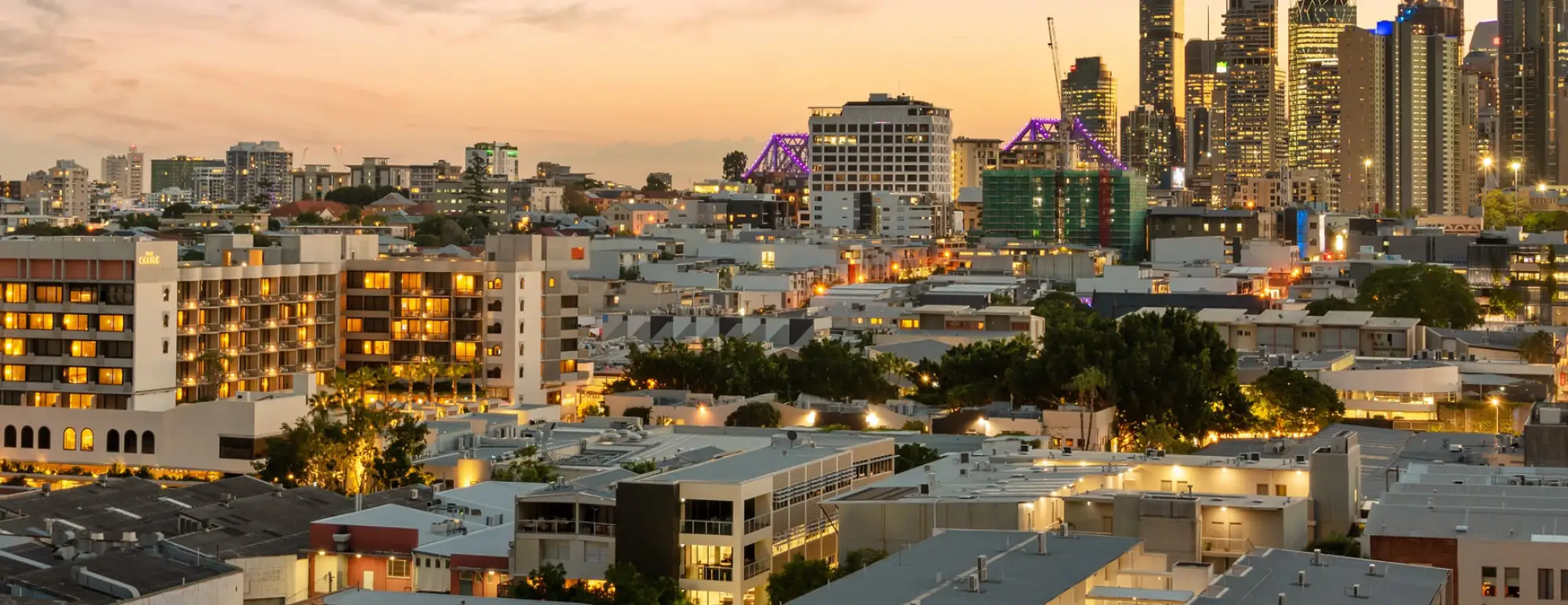 A sun sets over a city skyline.