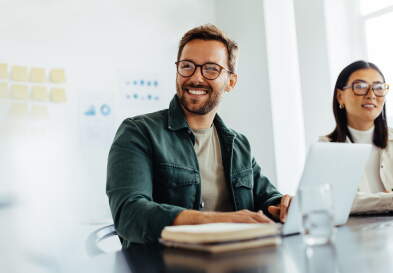 Smiling businessman listening to a discussion in an office.
