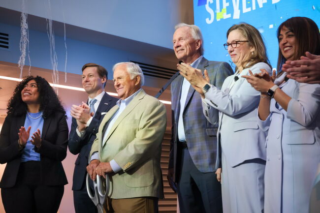 A group on stage at the grand opening celebration, including Chancellor Roberts and Steven D. Bell.