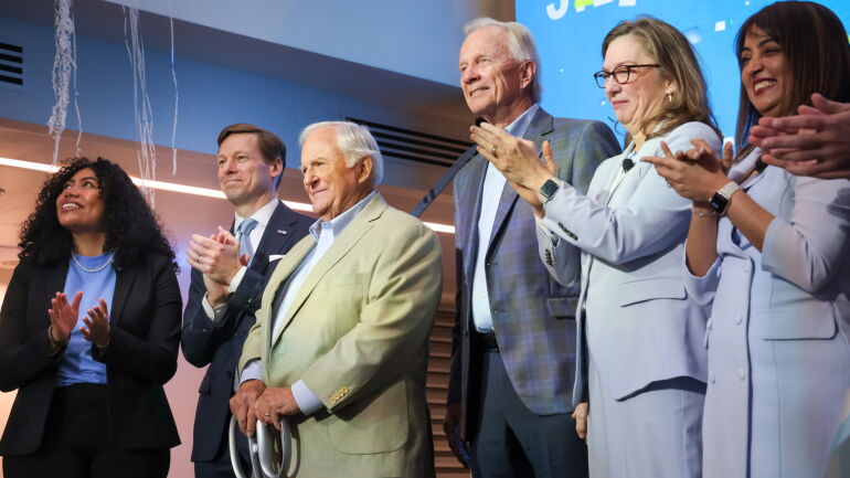 A group on stage at the grand opening celebration, including Chancellor Roberts and Steven D. Bell.