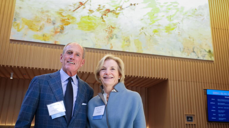 The Townsends underneath the large painting in the Tom Kenan Café.