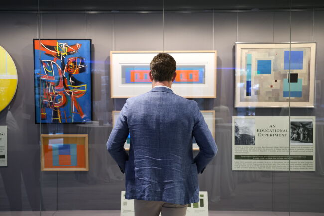 A man looks at the art collection inside of Bell Hall.