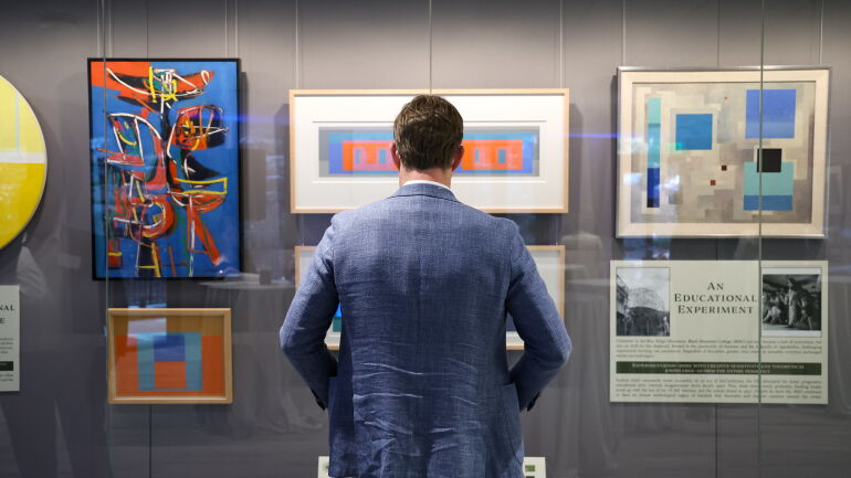 A man looks at the art collection inside of Bell Hall.