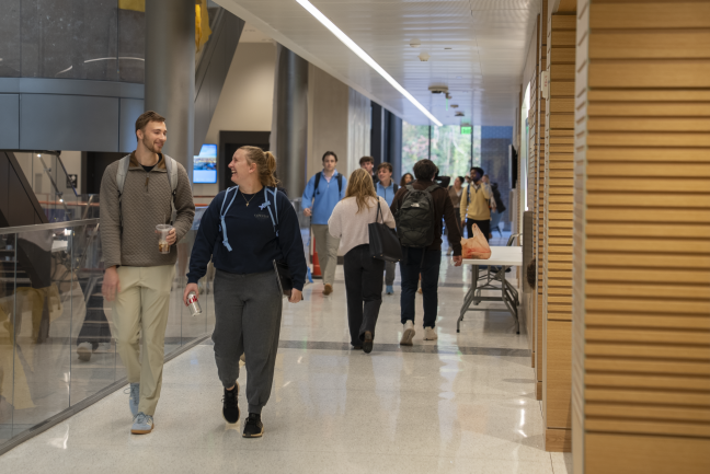 Students laugh while walking down the hall of Bell Hall.