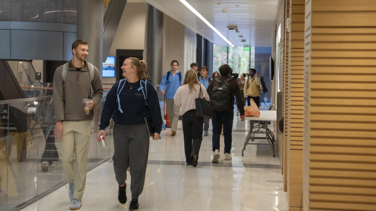 Students laugh while walking down the hall of Bell Hall.