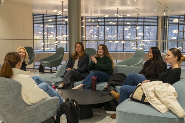 Students chat on couches in a common area in Bell Hall.