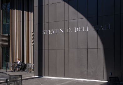 A shadow goes through the Bell Hall lettering on the entrance on the bridge from McColl Building.