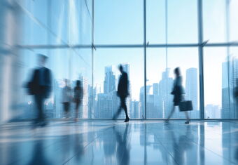 Blurred figures walking in a modern office building