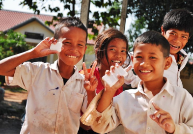 Children holding bars of soap and smiling at camera