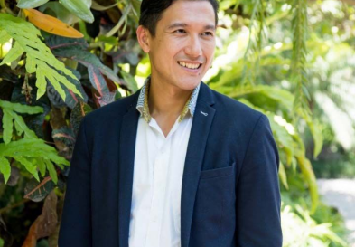 Jerry Winata standing in front of trees smiling